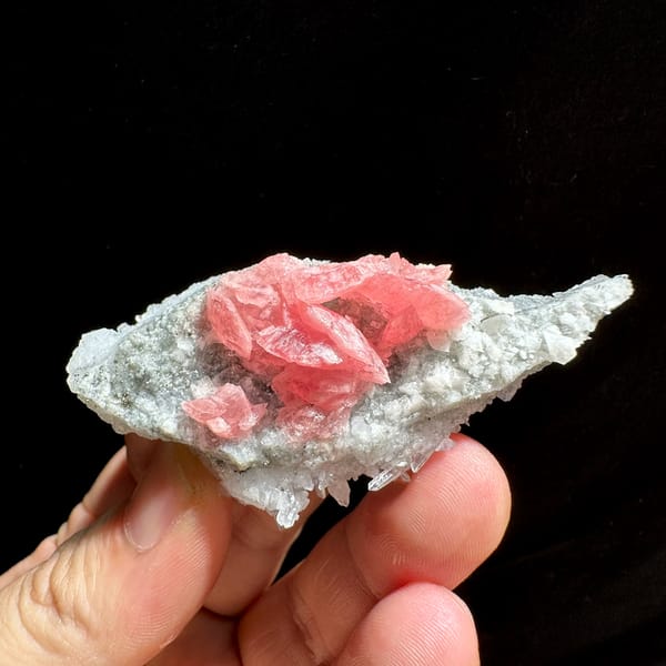 Rose-pink rhodochrosite cluster on white quartz needles from Wuzhou, Guangxi, China, close-up of the crystal faces