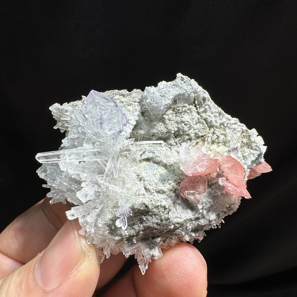 Pink rhodochrosite and purple fluorite with quartz needles from Wuzhou, Guangxi, China, detail of the matrix contact
