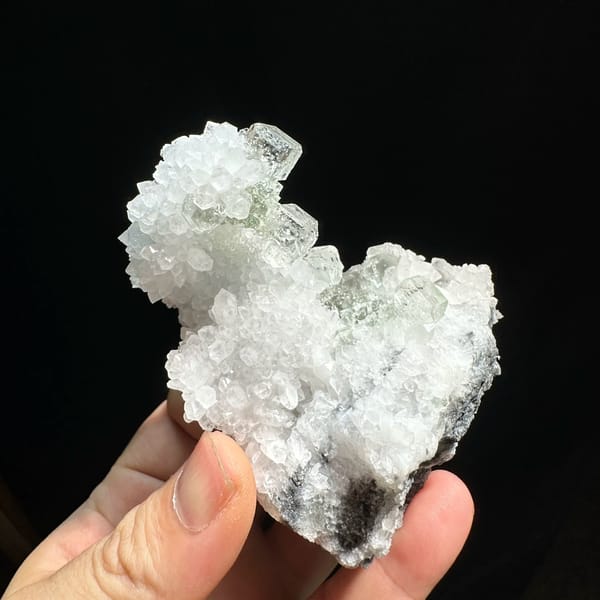 Transparent green fluorite cubes with inclusions on white quartz from Guangdong, China, close-up of the crystal faces