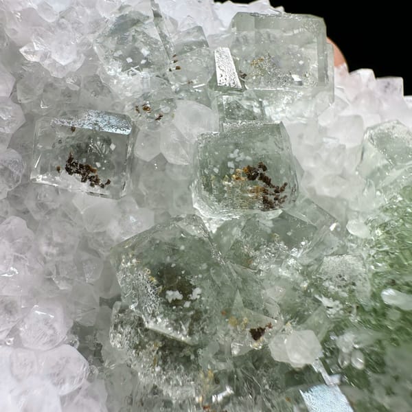 Stepped glassy green fluorite with inclusions on white quartz from Guangdong, China, top view