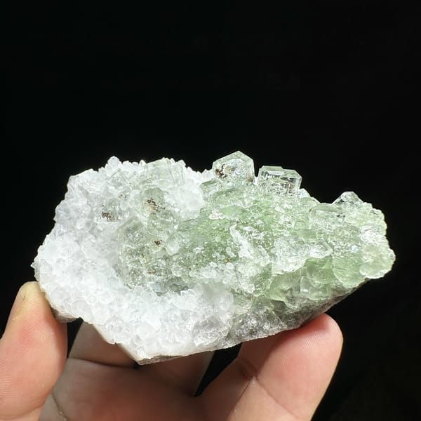 Stepped glassy green fluorite with inclusions on white quartz from Guangdong, China, detail of the matrix contact