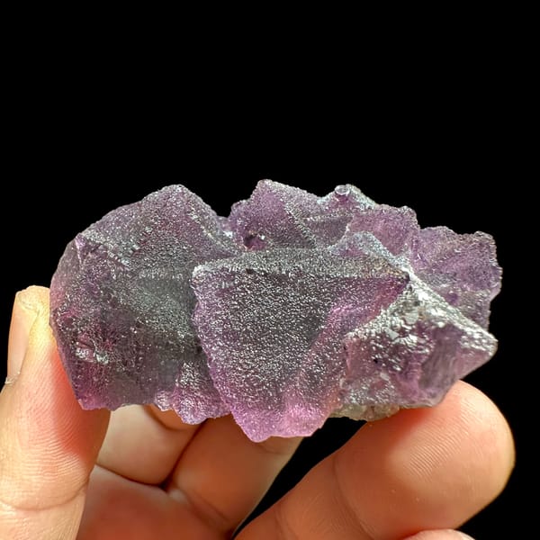 Purple and green stepped octahedral fluorite from Zhejiang, China, close-up of the crystal faces