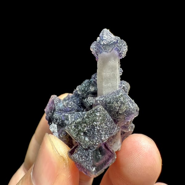 Violet fluorite octahedra on pale quartz prism from Inner Mongolia, China, close-up of the crystal faces