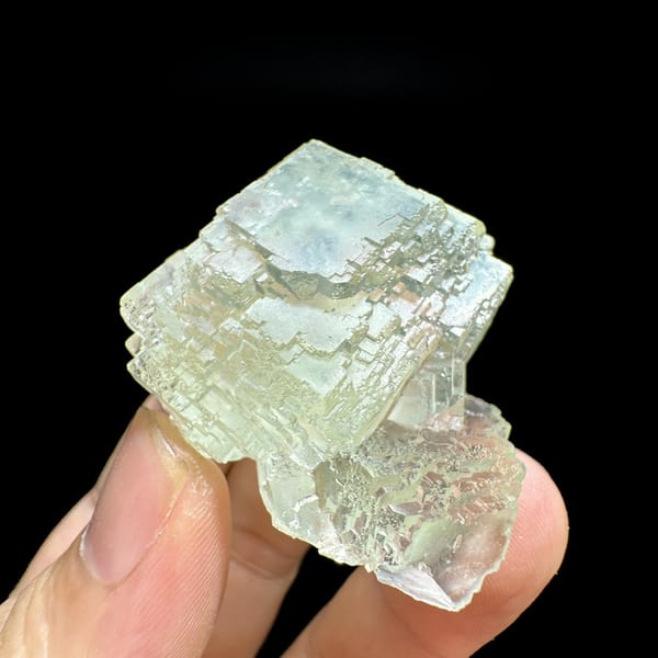 Glass-clear pale green fluorite cube from Guangdong, China, detail of the matrix contact
