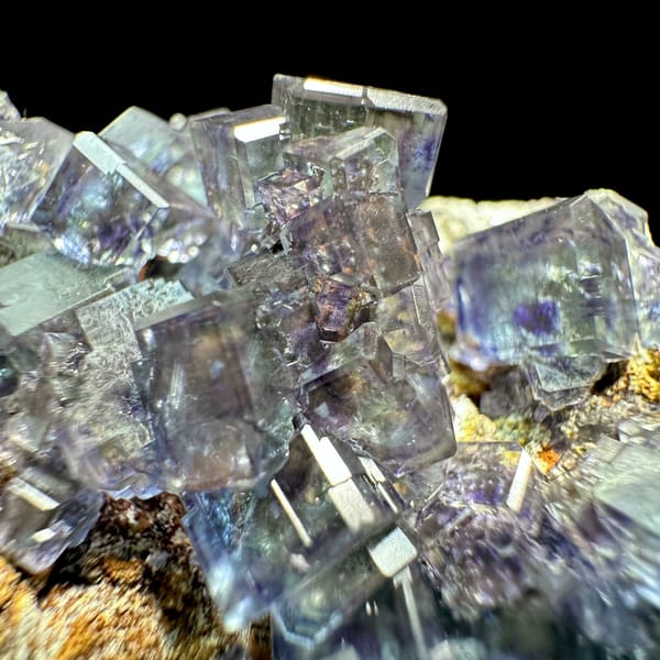 Glassy blue-green phantom fluorite cubes with pyrite dust from Fujian, China, close-up of the crystal faces