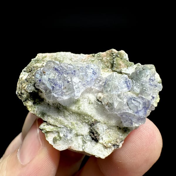Pale blue fluorite octahedra on white feldspar from Yunxiao, Fujian, China, detail of the matrix contact