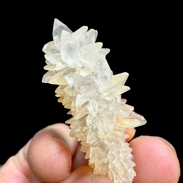 Slender pillar of stacked white calcite crystals from Yunnan, China, close-up of the crystal faces