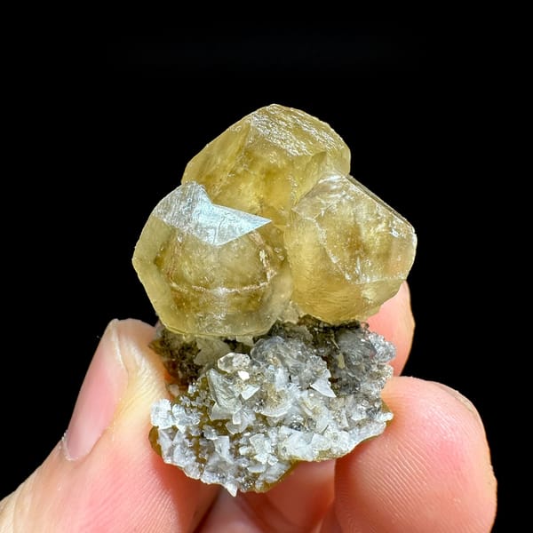 Glassy yellow calcite crystals with dolomite and siderite from Guizhou, China, held in hand
