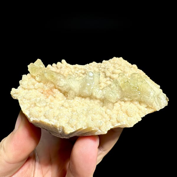 Pale cream feather-calcite plate from Hubei, China, held in hand