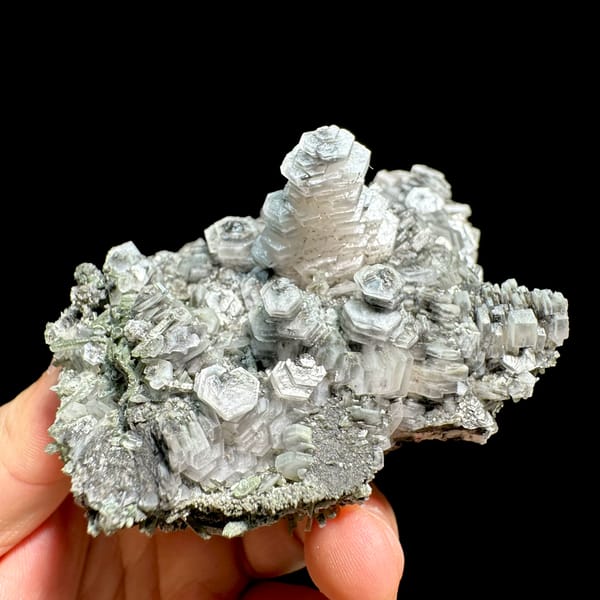 Hexagonal tower calcite crystals on grey quartz from Fujian, China, close-up of the crystal faces