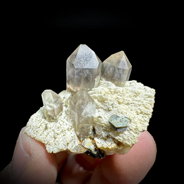 Pale smoky quartz points on cream feldspar with mica from Yunxiao, Fujian, China, top view