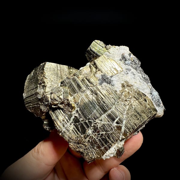 Heavy brass-gold pyrite block with striated faces and galena from Hunan, China, detail of the matrix contact