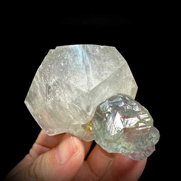 Large translucent star calcite with glassy blue-green fluorite from Fujian, China, held in hand