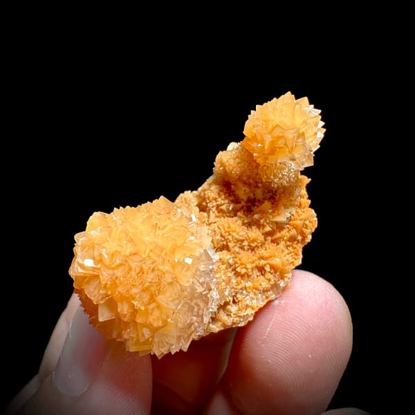 Two peach-orange botryoidal calcite balls from Yunnan, China, close-up of the crystal faces