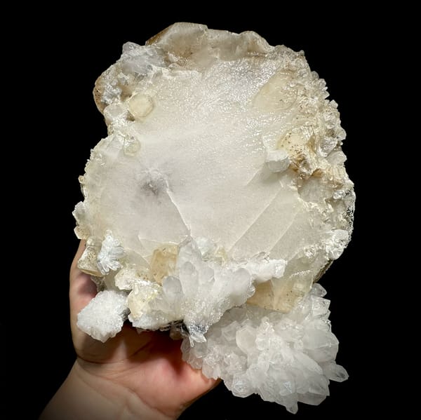Huge tabular calcite plate over sparkling quartz from Fujian, China, close-up of the crystal faces