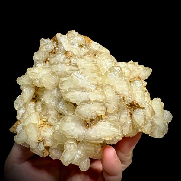 Mound of hammer-headed cream calcite crystals from Guizhou, China, close-up of the crystal faces
