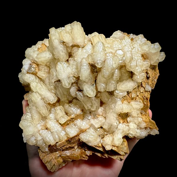 Hammer-headed calcite crystals over golden siderite from Guizhou, China, close-up of the crystal faces
