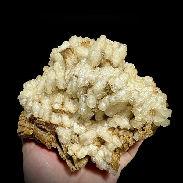 Hammer-headed calcite crystals over golden siderite from Guizhou, China, detail of the matrix contact