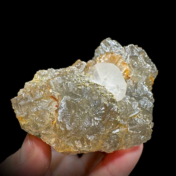 Glassy yellow fluorite with white calcite blade and pyrite from Xianghualing, Hunan, China, close-up of the crystal faces