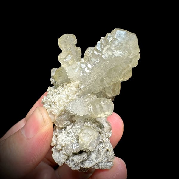 Cream calcite cross with stacked crystals over dolomite from Guizhou, China, close-up of the crystal faces