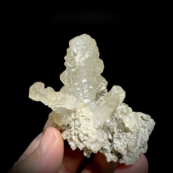 Cream calcite cross with stacked crystals over dolomite from Guizhou, China, detail of the matrix contact
