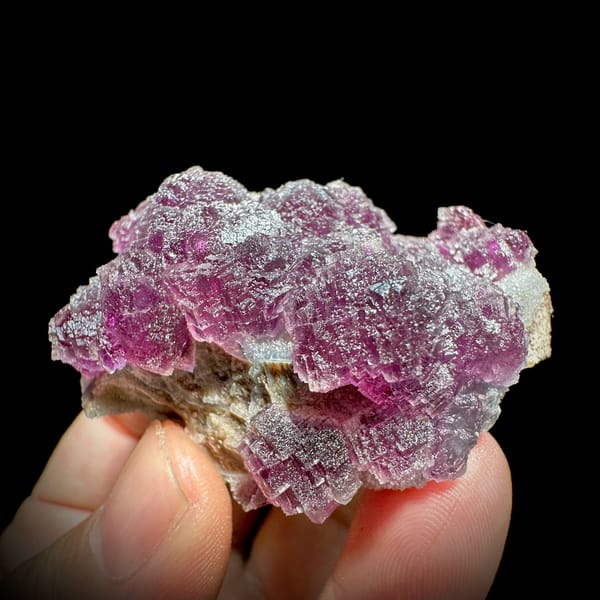 Raspberry-purple stepped fluorite crystals from Zhejiang, China, close-up of the crystal faces
