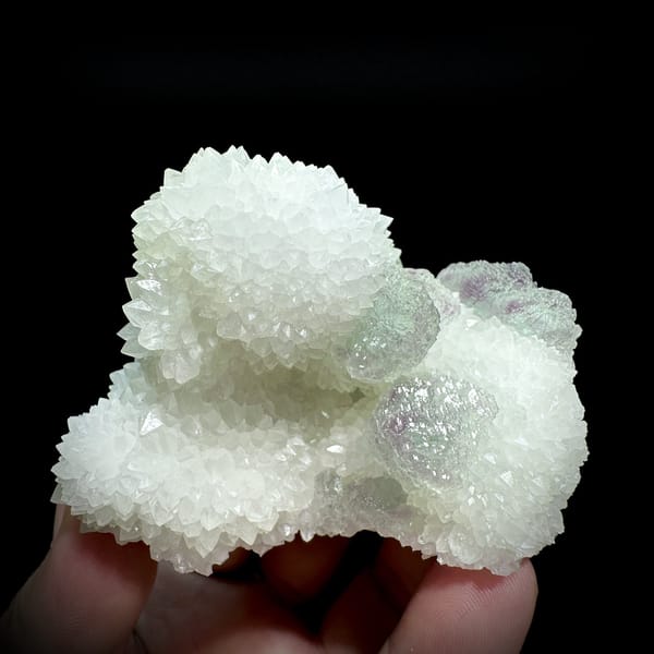 Purple-green fluorite balls beside white quartz needles from Fujian, China, detail of the matrix contact