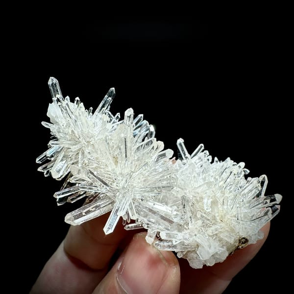 Transparent chrysanthemum quartz spray from Jinkouhe, Sichuan, China, held in hand