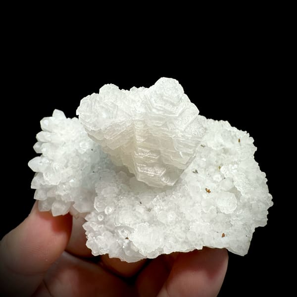 Stacked pagoda calcite tower on white quartz from Guangdong, China, close-up of the crystal faces