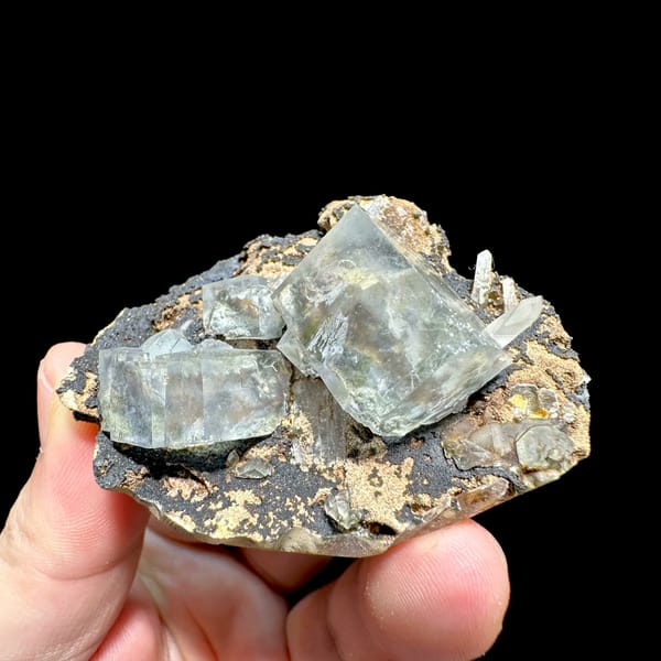Transparent fluorite cubes on dark tan-crusted matrix from Fujian, China, second angle