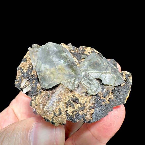 Transparent fluorite cubes on dark tan-crusted matrix from Fujian, China, top view
