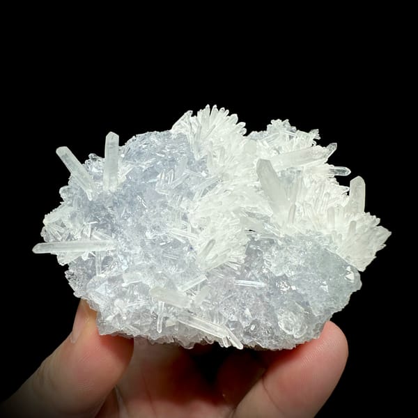 Clear quartz needles over pale blue fluorite from Fujian, China, close-up of the crystal faces
