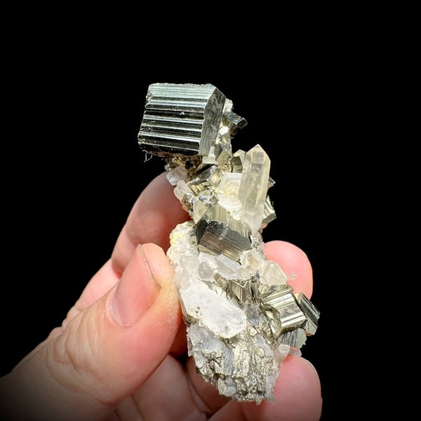 Striated pyrite cube on clear quartz and calcite from Indonesia, close-up of the crystal faces