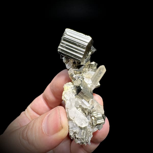 Striated pyrite cube on clear quartz and calcite from Indonesia, detail of the matrix contact
