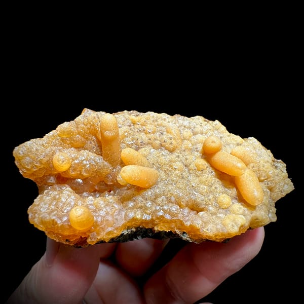 Orange caterpillar-form calcite over cream botryoidal plate from Yunxiao, Fujian, China, second angle