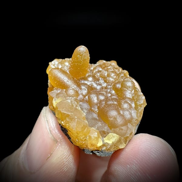 Tiny orange caterpillar-form calcite from Yunxiao, Fujian, China, detail of the matrix contact