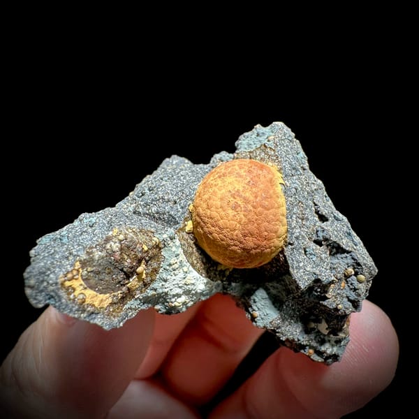 Egg-yolk orange calcite ball in grey pocket from Fujian, China, second angle
