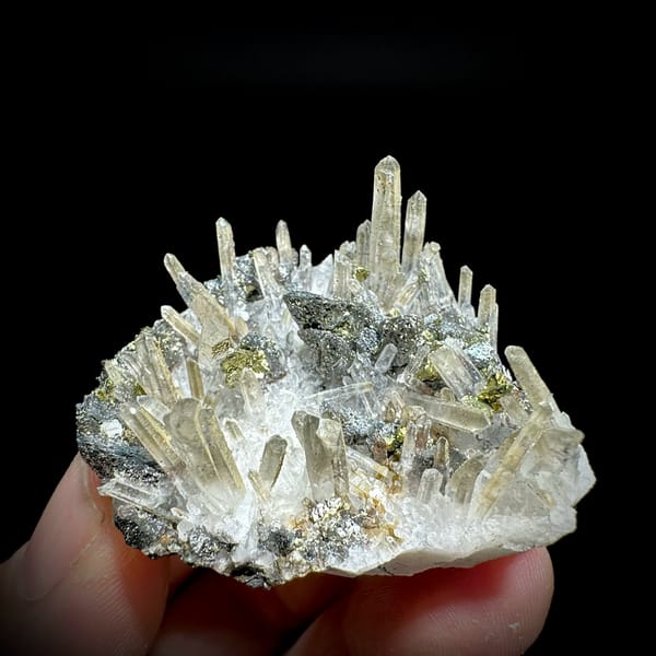 Clear quartz needles over chalcopyrite and freibergite from Inner Mongolia, China, held in hand