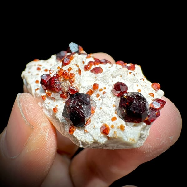 Wine-red garnet crystals on cream feldspar from Yunxiao, Fujian, China, close-up of the crystal faces