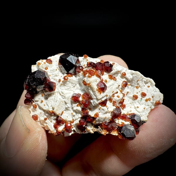Wine-red garnet crystals on cream feldspar from Yunxiao, Fujian, China, detail of the matrix contact