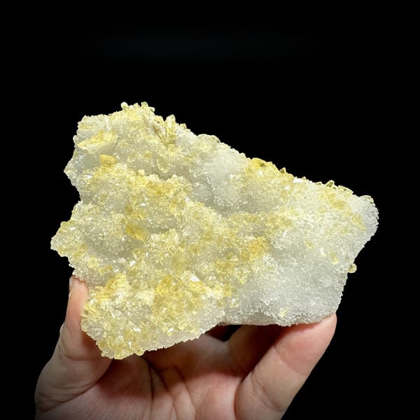 White quartz druse plate with yellow baryte crusts from Jiangxi, China, detail of the matrix contact