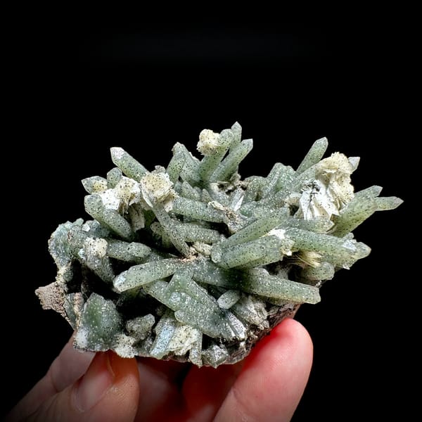 Pale green chlorite quartz prisms with calcite from Inner Mongolia, China, held in hand