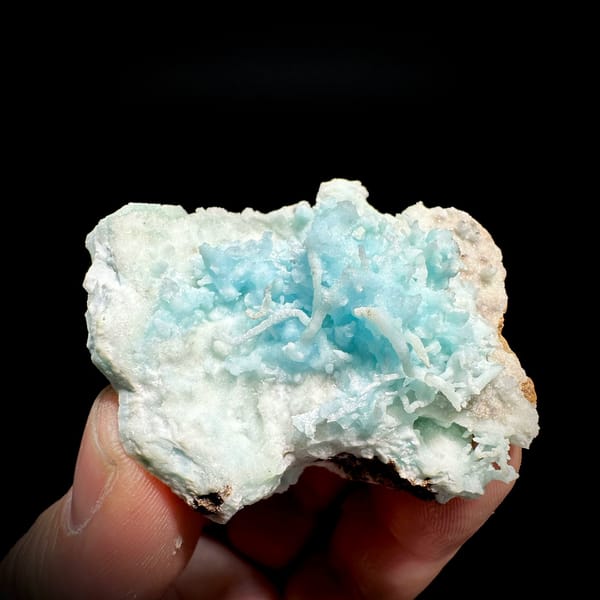 Sky-blue stalactitic aragonite in white aragonite frame from Yunnan, China, held in hand