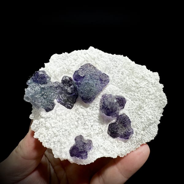 Frosted purple fluorite cubes on white sugar-quartz plate from Zhejiang, China, detail of the matrix contact