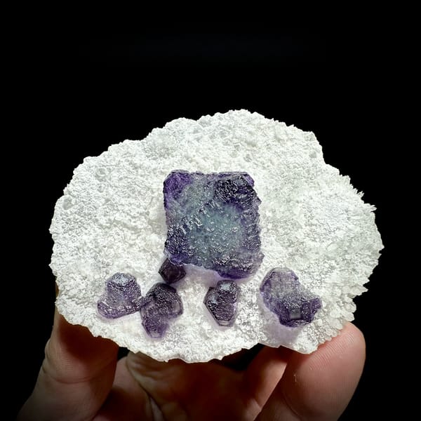Large purple fluorite cube with small cubes on white quartz plate from Zhejiang, China