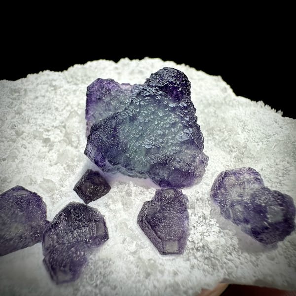 Large purple fluorite cube with small cubes on white quartz plate from Zhejiang, China, second angle