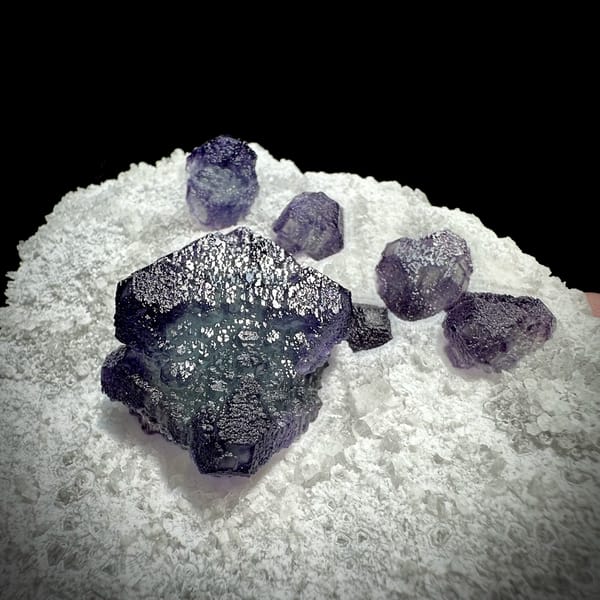 Large purple fluorite cube with small cubes on white quartz plate from Zhejiang, China, reverse side