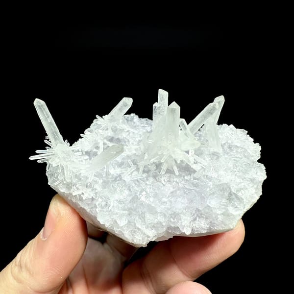 Fluorite base with spray of clear quartz needles from Fujian, China, held in hand