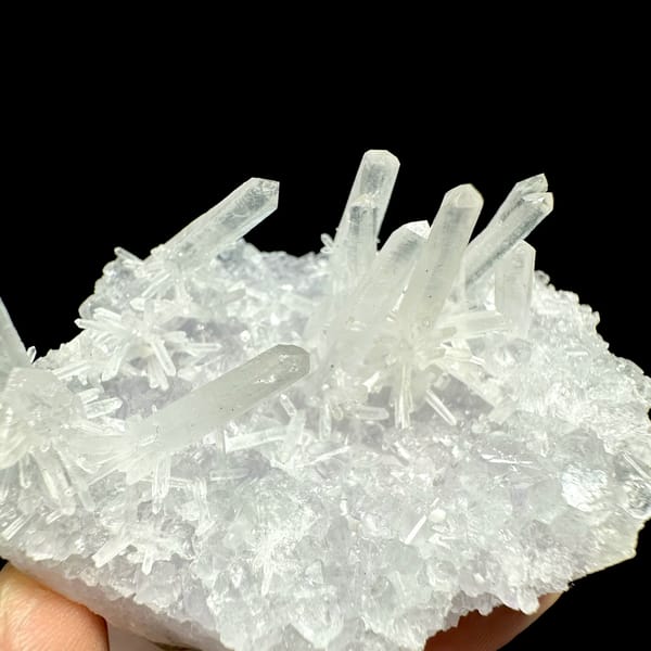 Fluorite base with spray of clear quartz needles from Fujian, China, close-up of the crystal faces