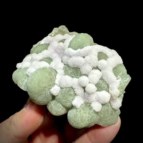 Mint-green fluorite balls laced with white fluorite from Henan, China, close-up of the crystal faces